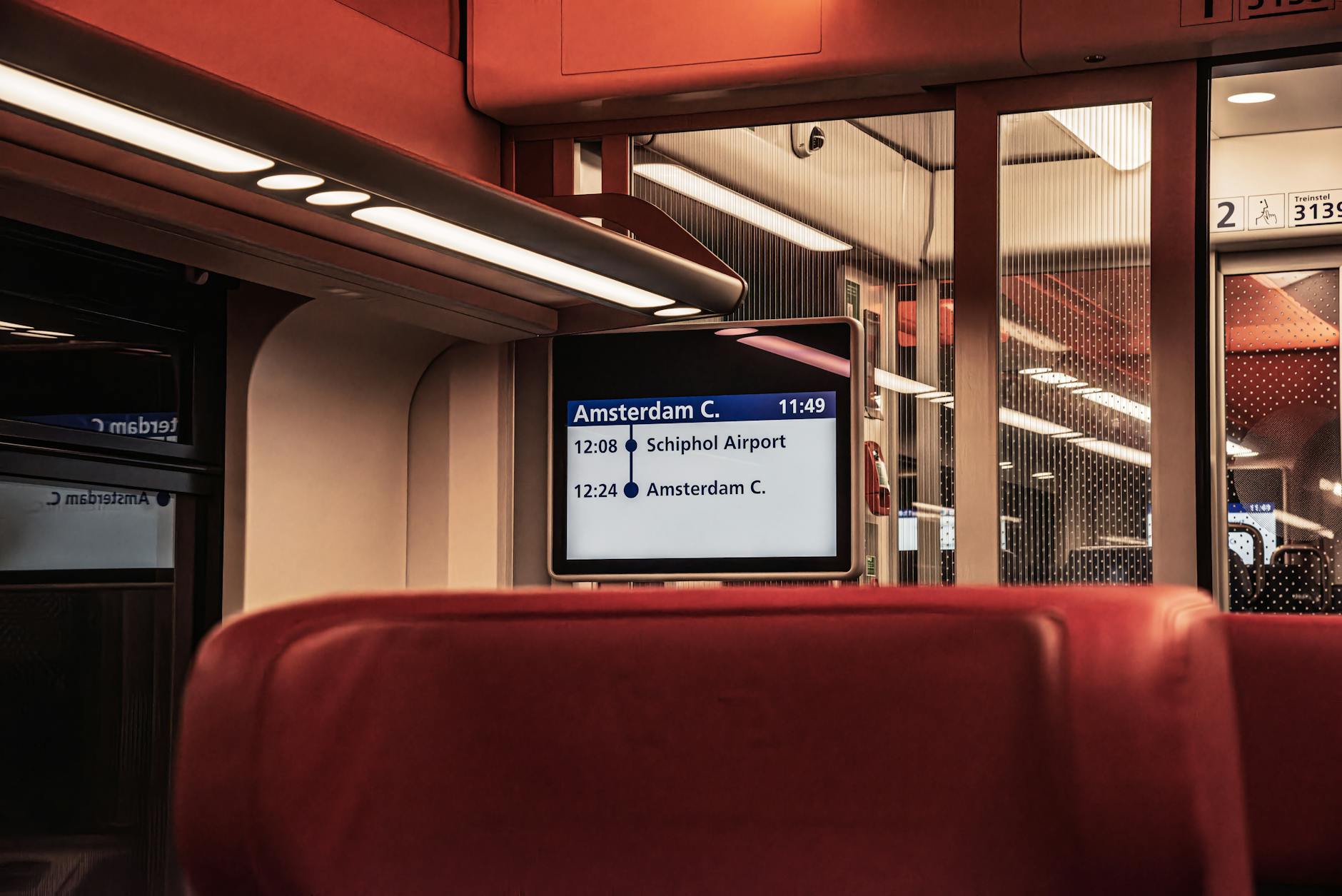 Wnętrze pociągu z tablicą odjazdu do Amsterdamu z lotniska Schiphol