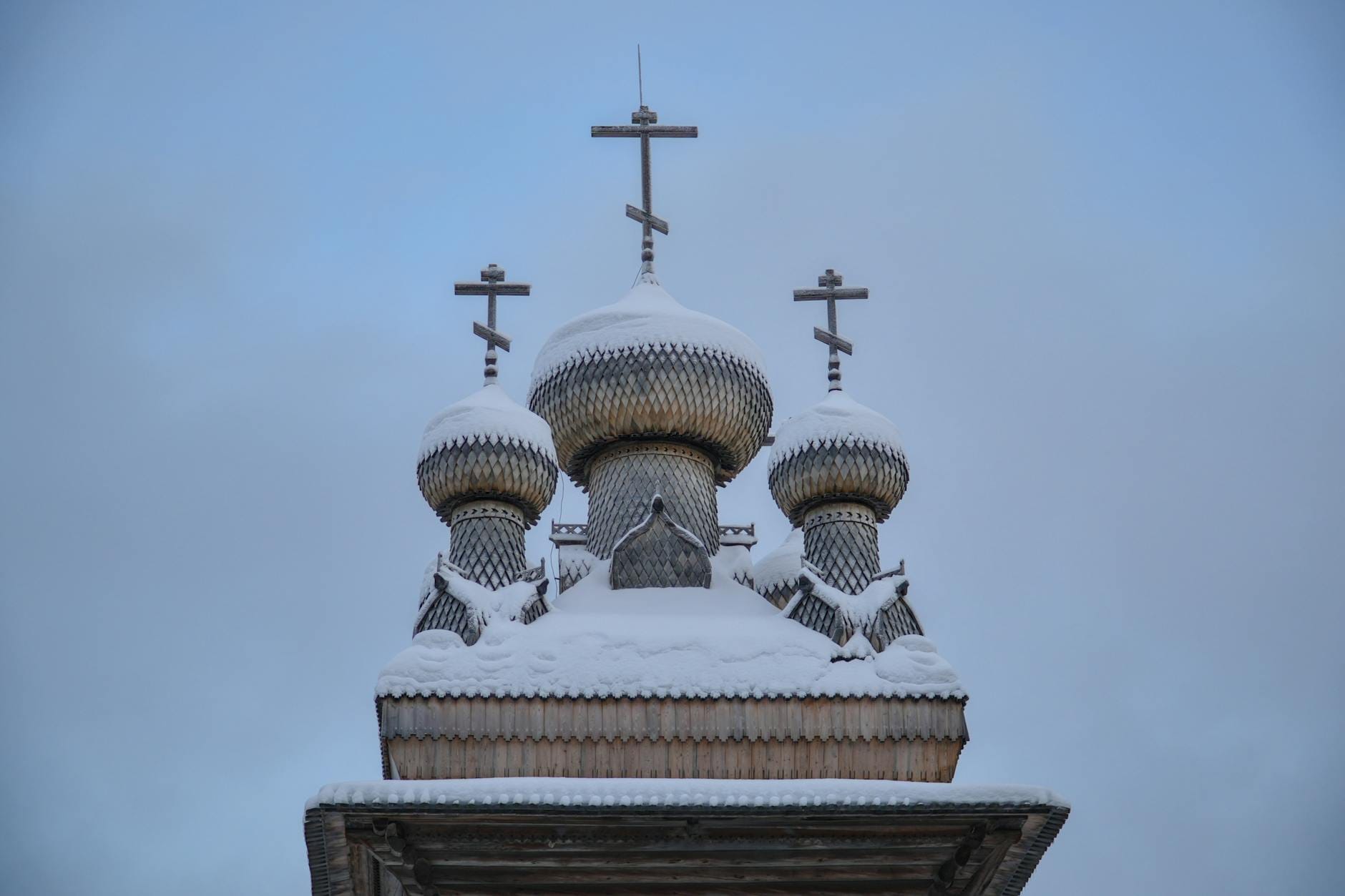 Drewniana cerkiew prawosławna zimą, ośnieżona, z tradycyjną wieżą Drewniana cerkiew prawosławna zimą, ośnieżona, z tradycyjną wieżą