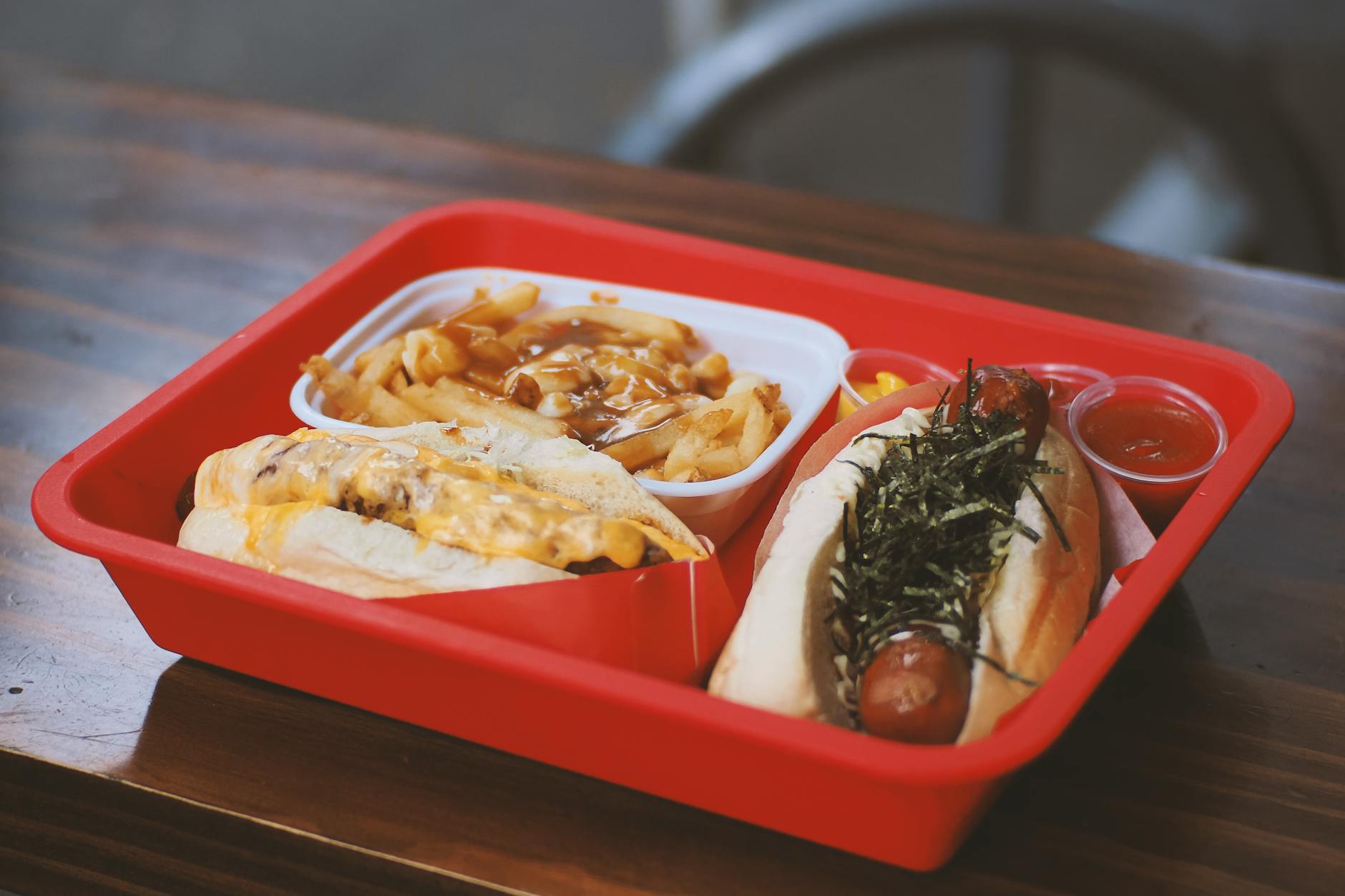 Poutine i hot dog Japadog w czerwonej tacce w Vancouver Poutine i hot dog Japadog w czerwonej tacce w Vancouver