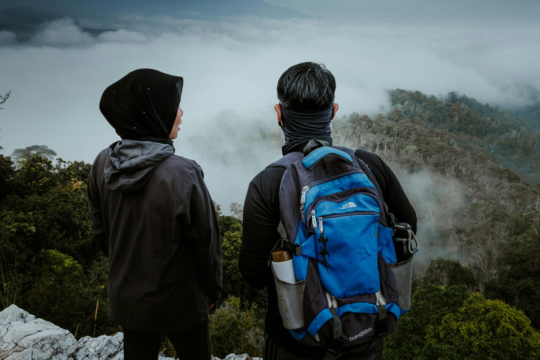 Dwóch turystów na klifie spogląda na mglisty las w Taman Negara