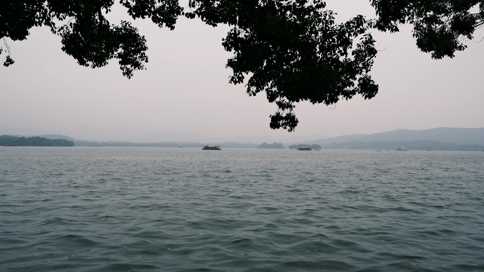 Spokojne wody Jeziora Zachodniego i wzgórza w Hangzhou