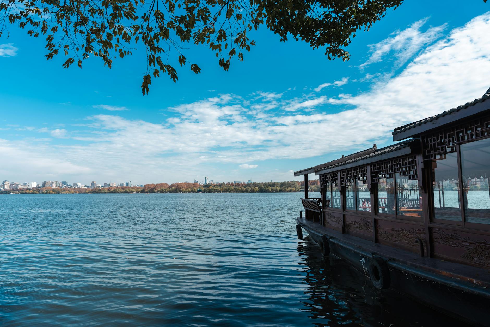 Tradycyjna łódź na spokojnych wodach West Lake w Hangzhou za dnia