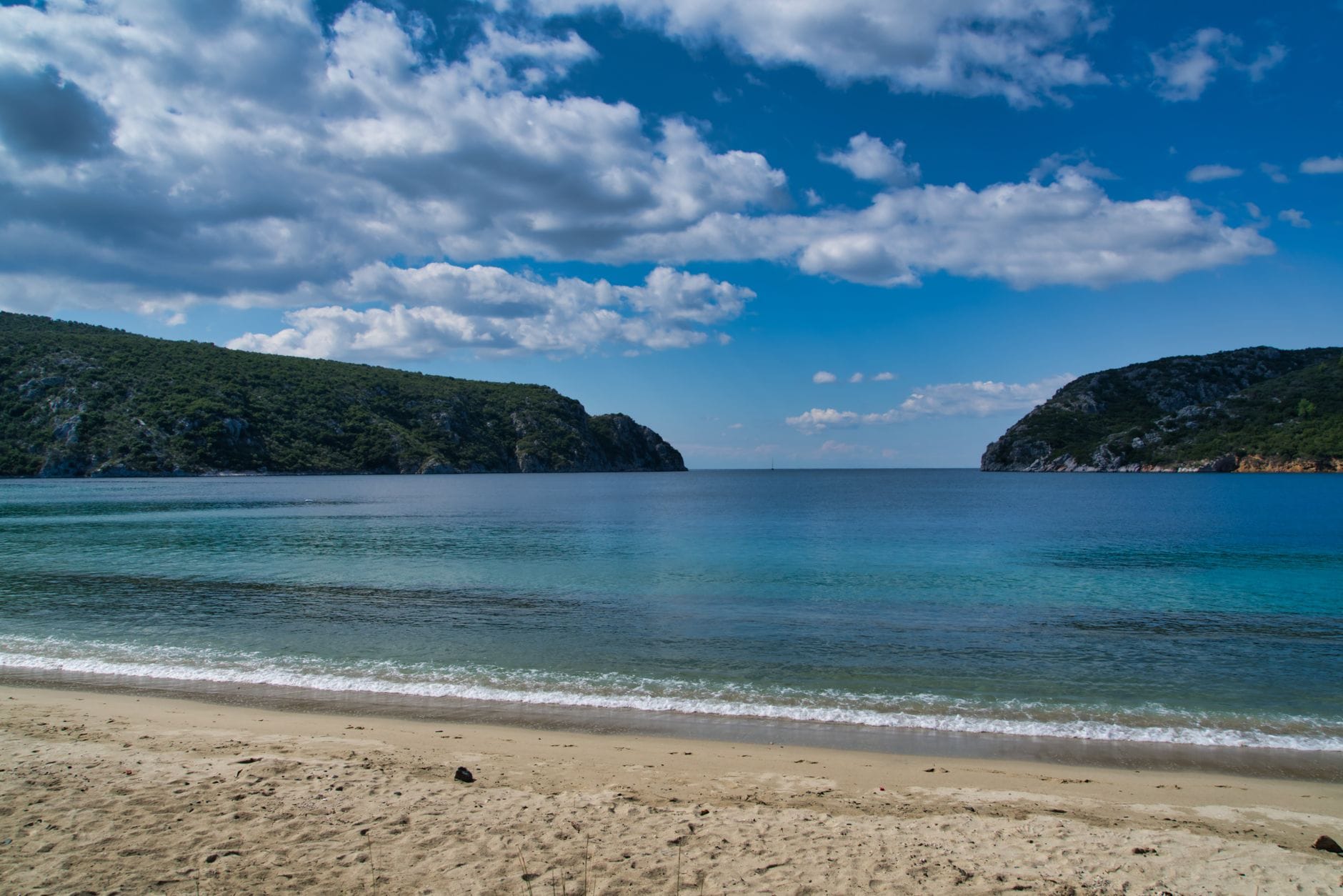 Kreta czy Rodos? Jak wybrać wyspę na pierwszy wyjazd do Grecji Spokojna grecka plaża z turkusową wodą i bezchmurnym niebem